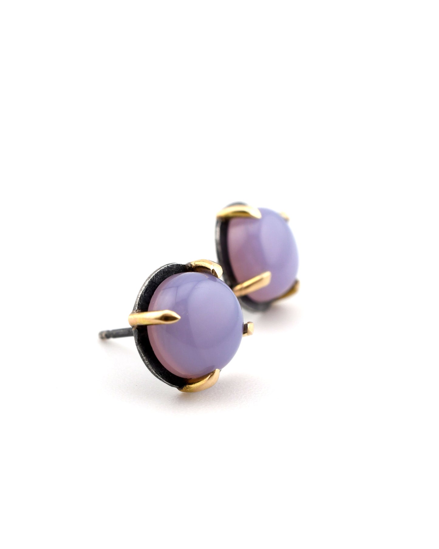 pair of round black silver and 14k gold studs with purple chalcedony on a white background