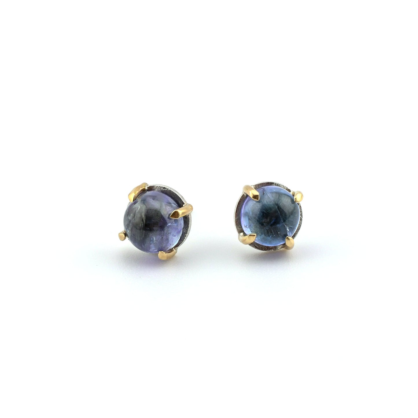 tanzanite studs in silver and 14k gold on a white background