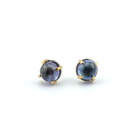 tanzanite studs in silver and 14k gold on a white background