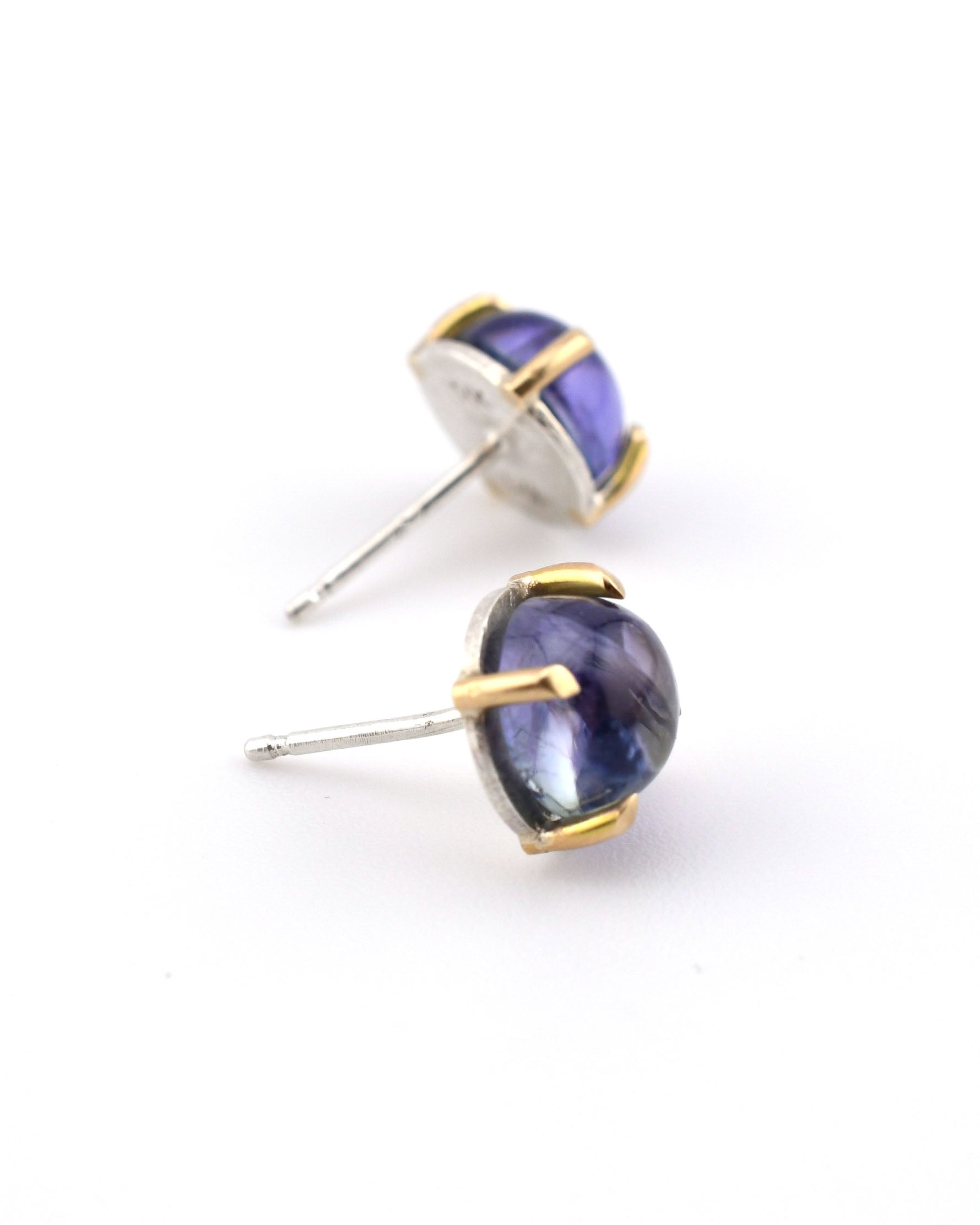pair of round silver and gold stud earrings with tanzanite on a white background