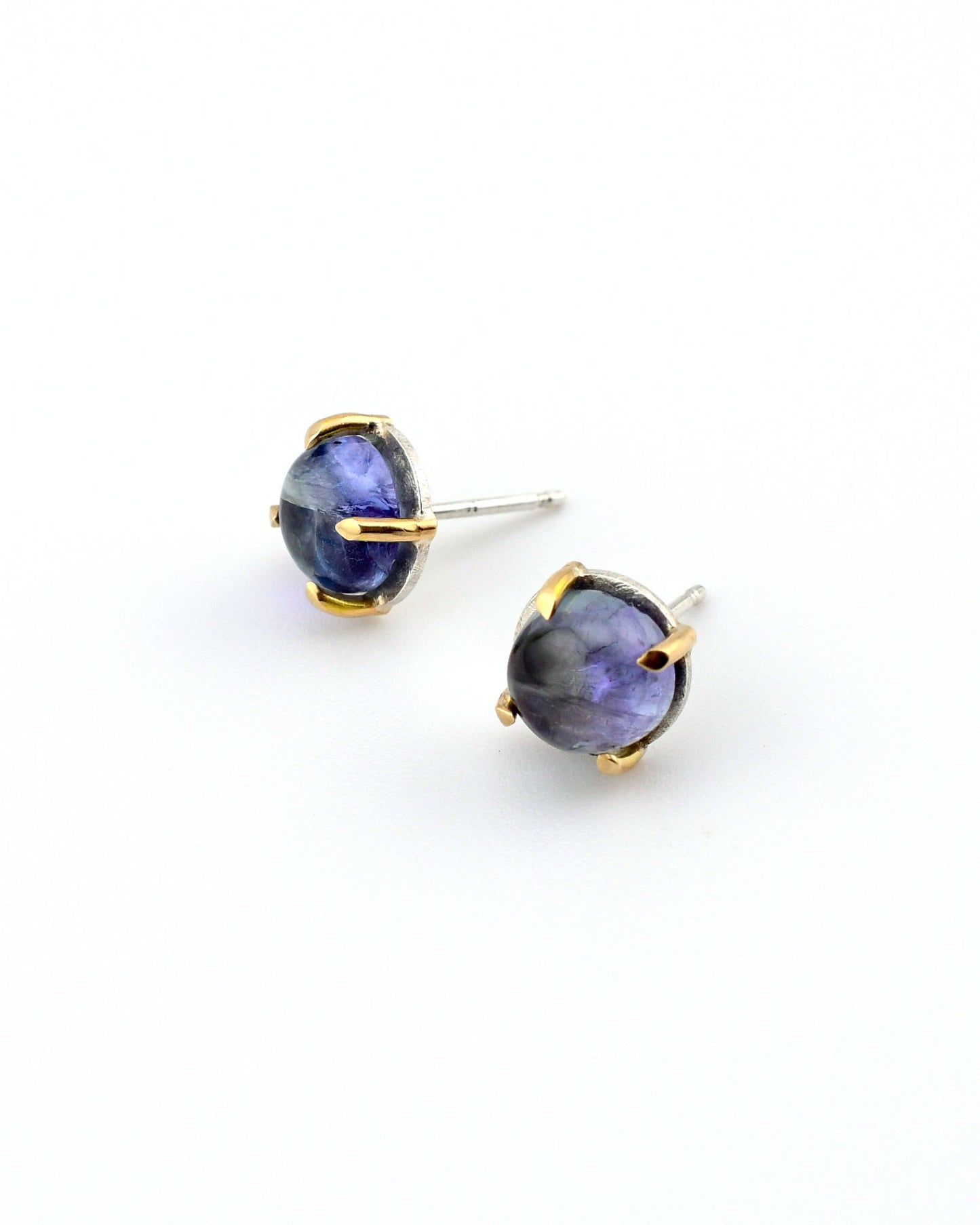 tanzanite stud earrings in silver and 14k gold on a white background