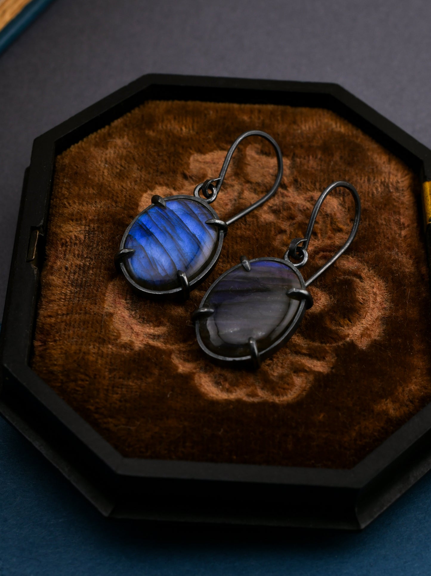 Blue gemstone earrings on a wooden display box