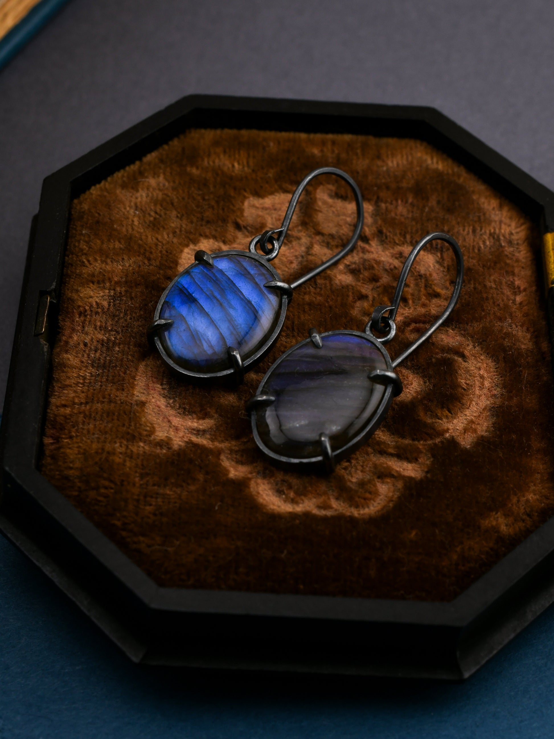 Blue gemstone earrings on a wooden display box