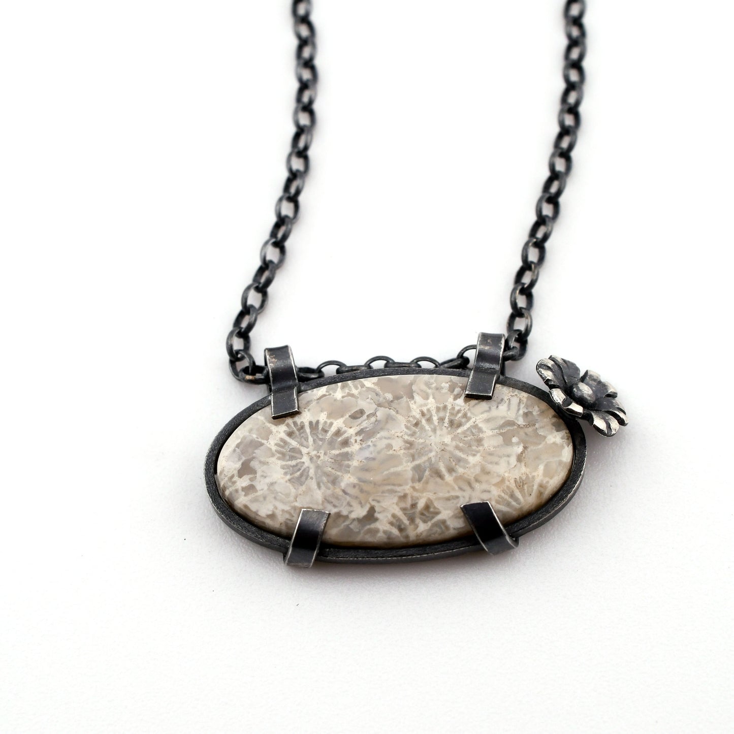 Necklace with a large oval pendant featuring a natural pattern on a white background