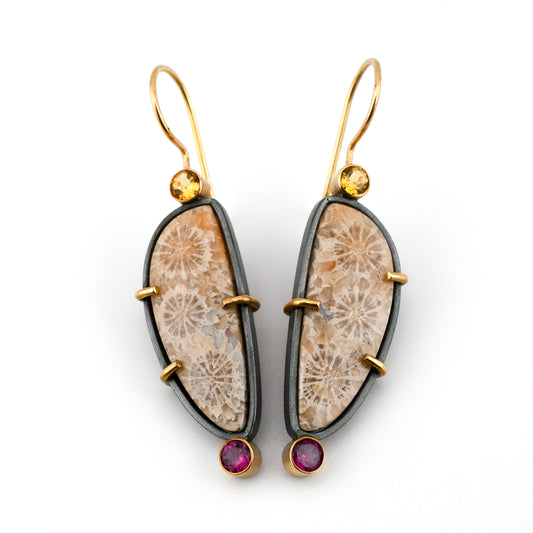 Coral earrings in soft pastel colors with black silver frames and gold ear wires and accents and faceted gemstones on a white background