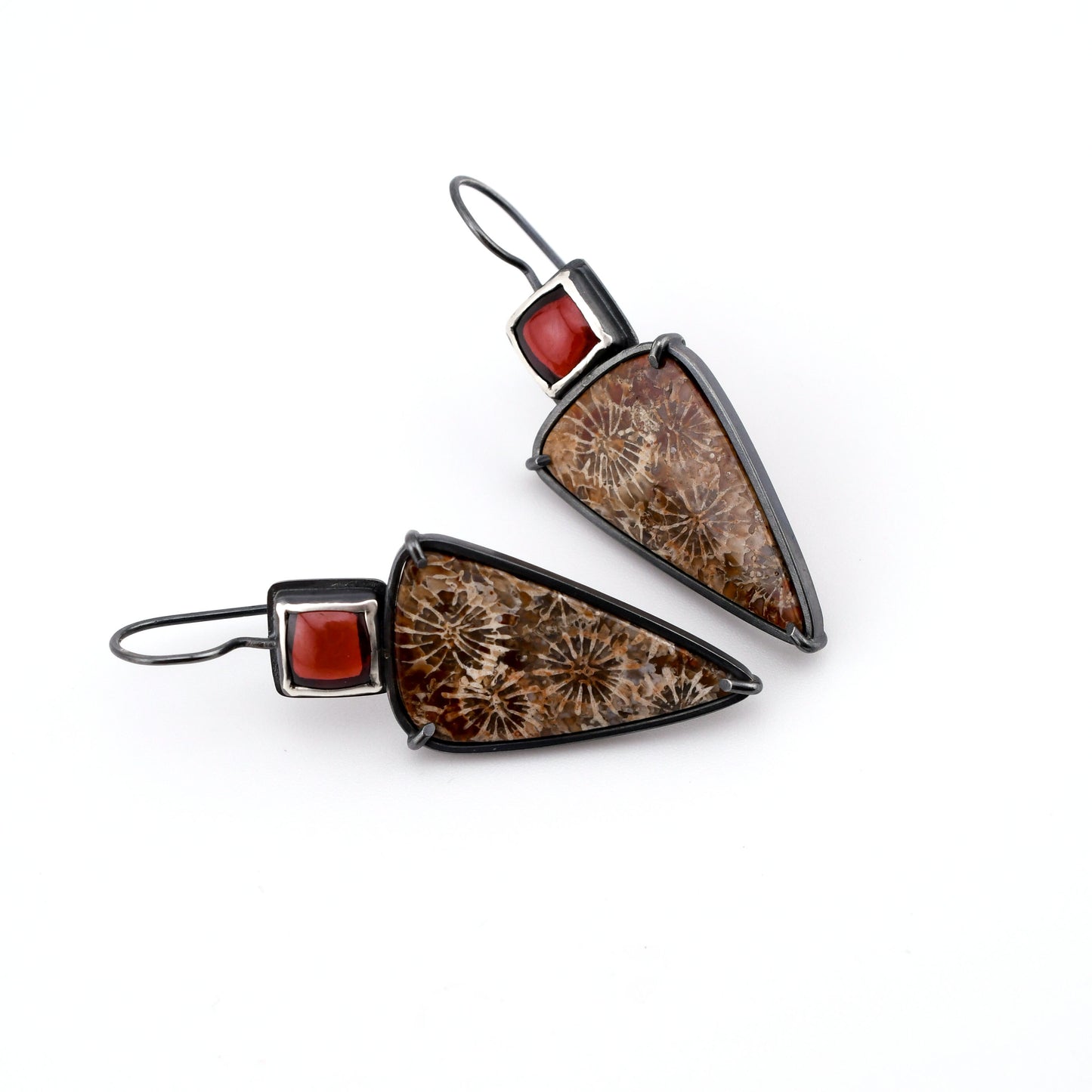 Pair of earrings with brown triangular stones and red accents on a white background