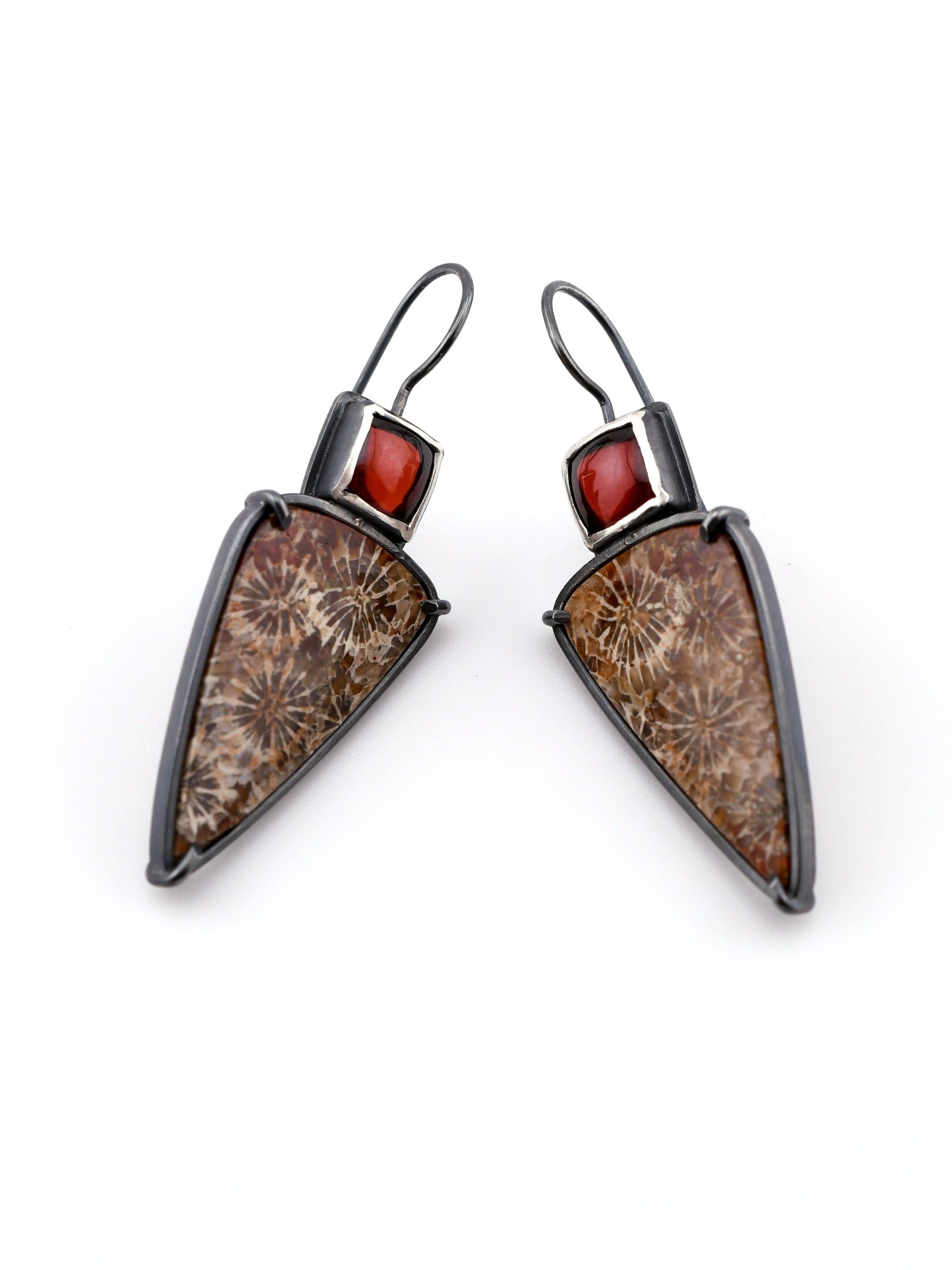 Pair of triangular-shaped earrings with brown and red stones on a white background