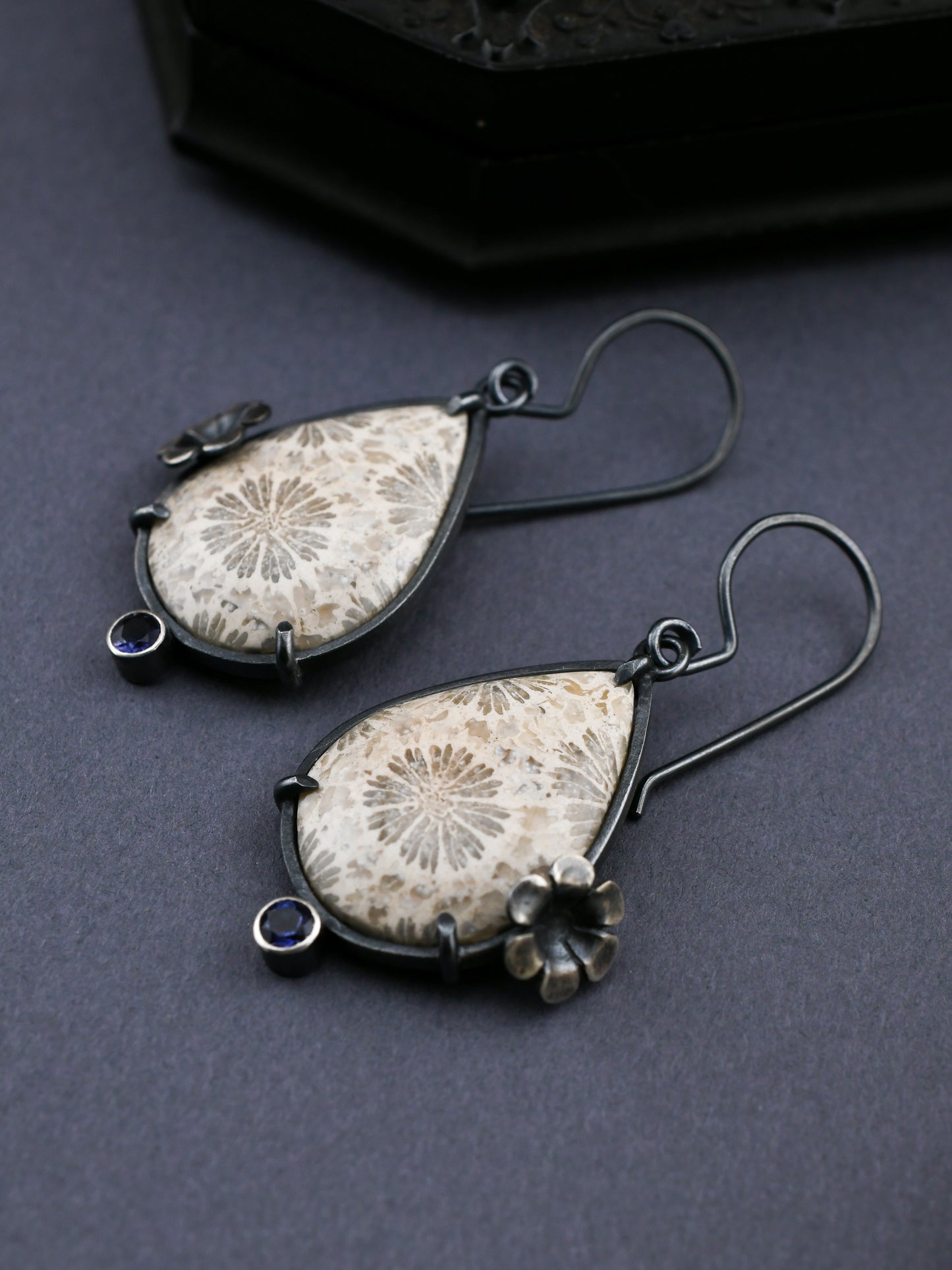 Pair of earrings with floral patterns on a dark background