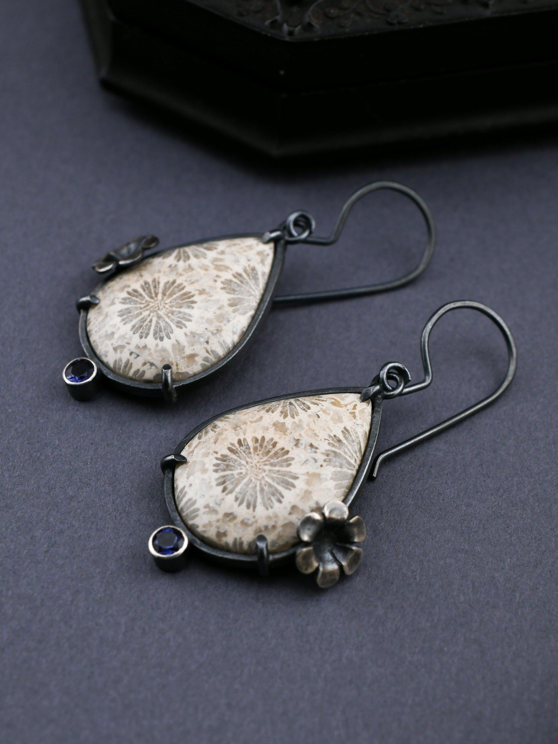Pair of earrings with floral patterns on a dark background