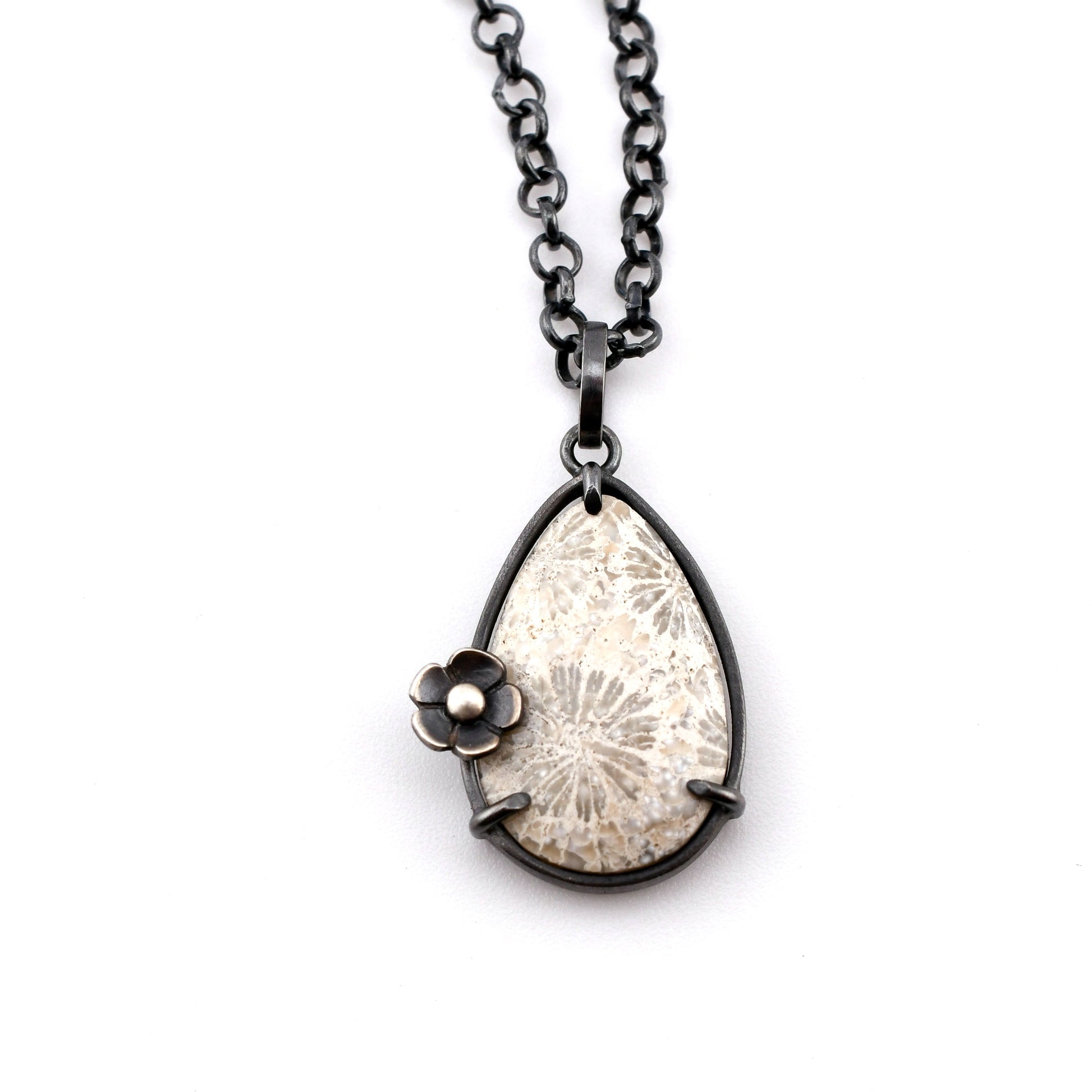 Necklace with a teardrop-shaped pendant featuring a floral design on a white background