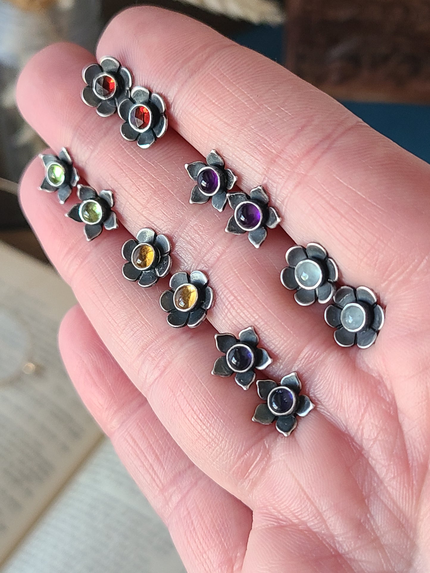 Hand holding 6 colorful gemstone flower studs