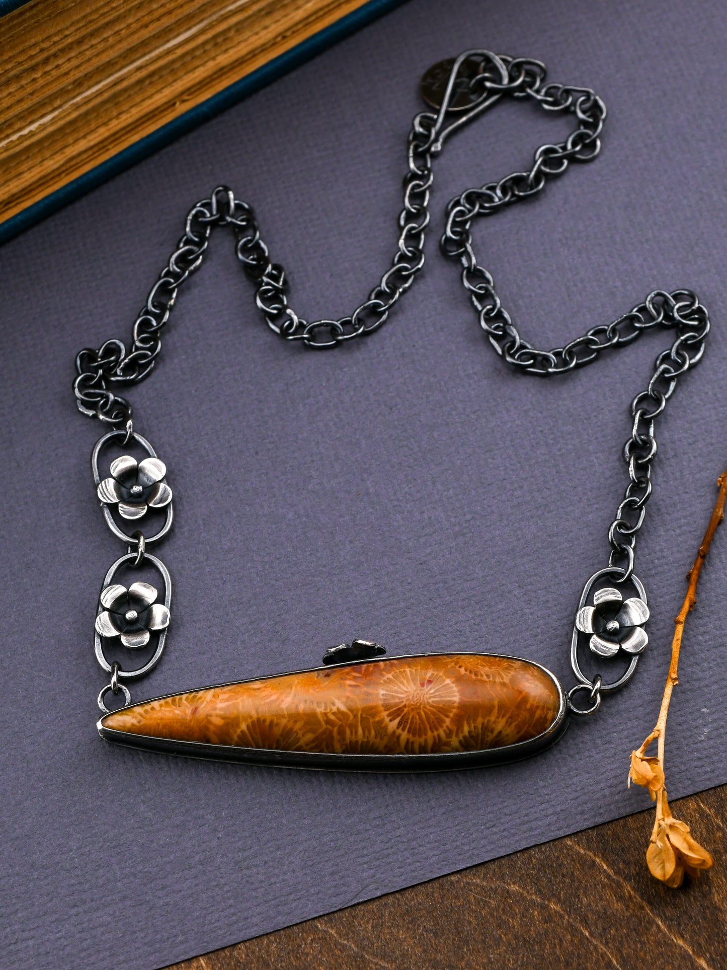 Necklace with a dark golden-colored pendant on a dark surface