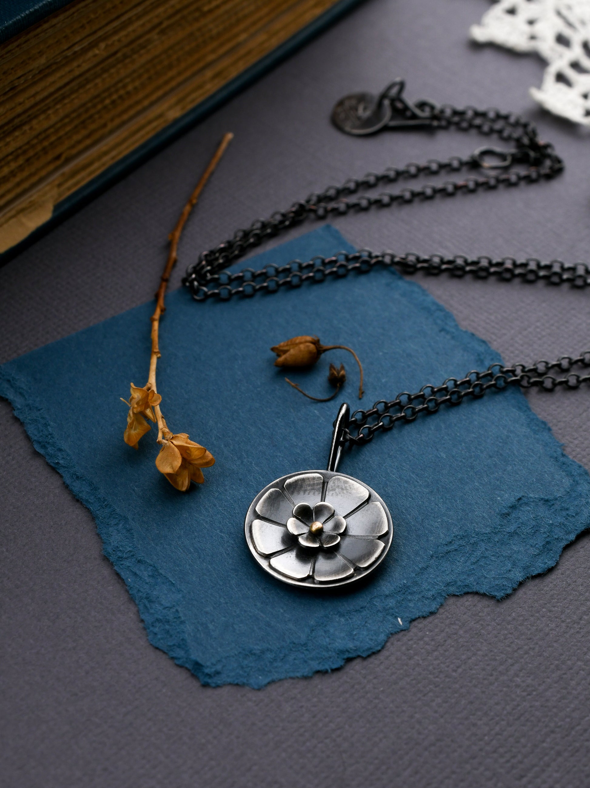 Necklace with a floral pendant on a blue surface