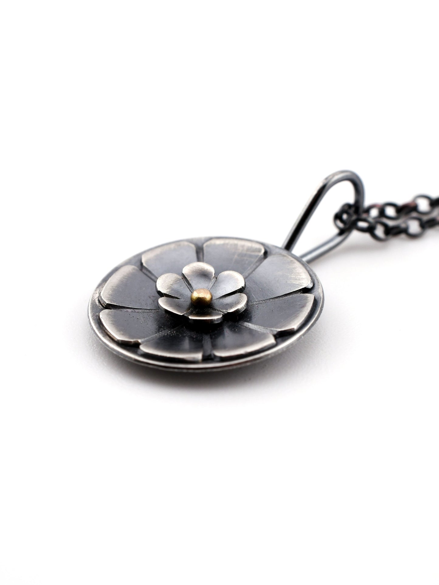 Silver necklace with a floral pendant on a white background