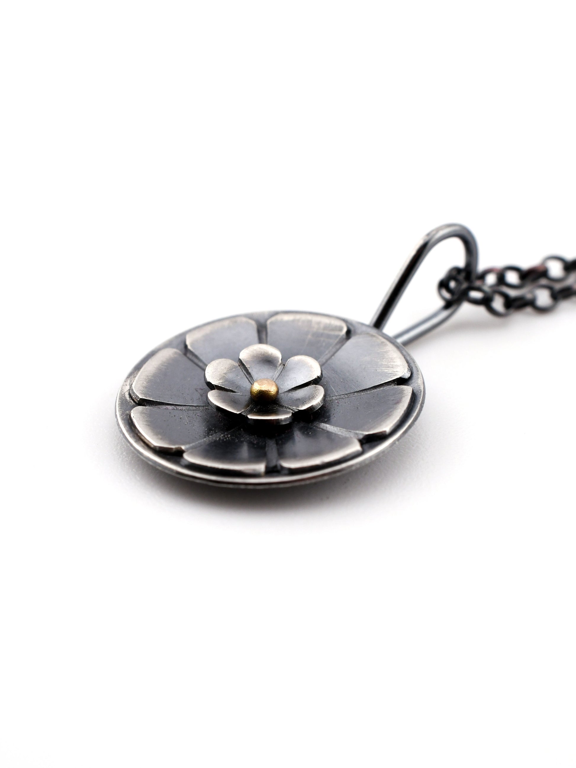 Silver necklace with a floral pendant on a white background