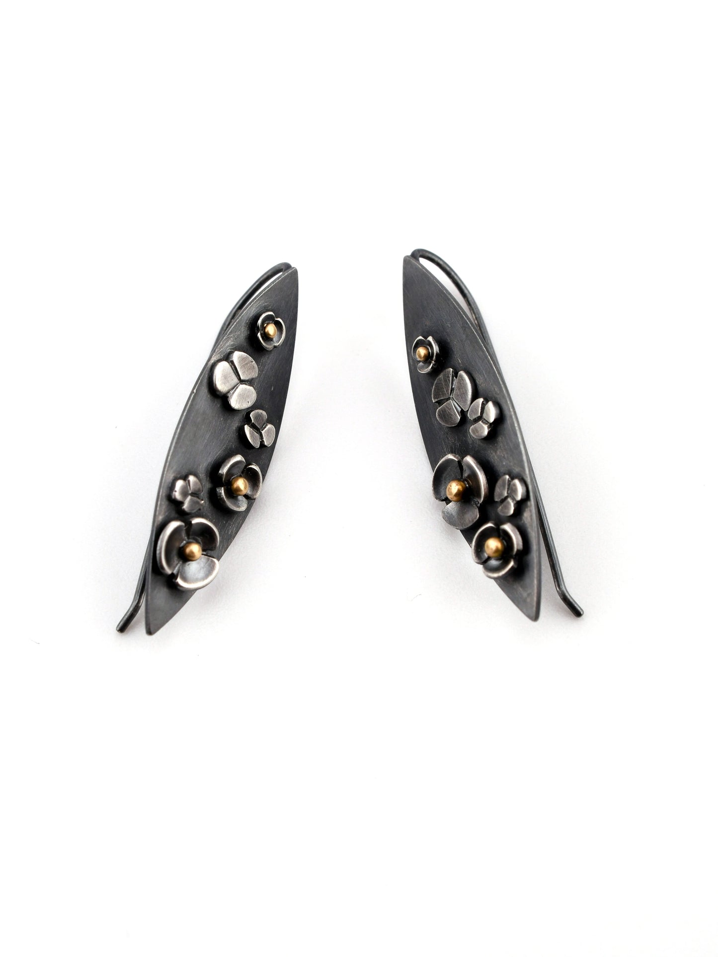 Pair of black earrings with floral designs on a white background