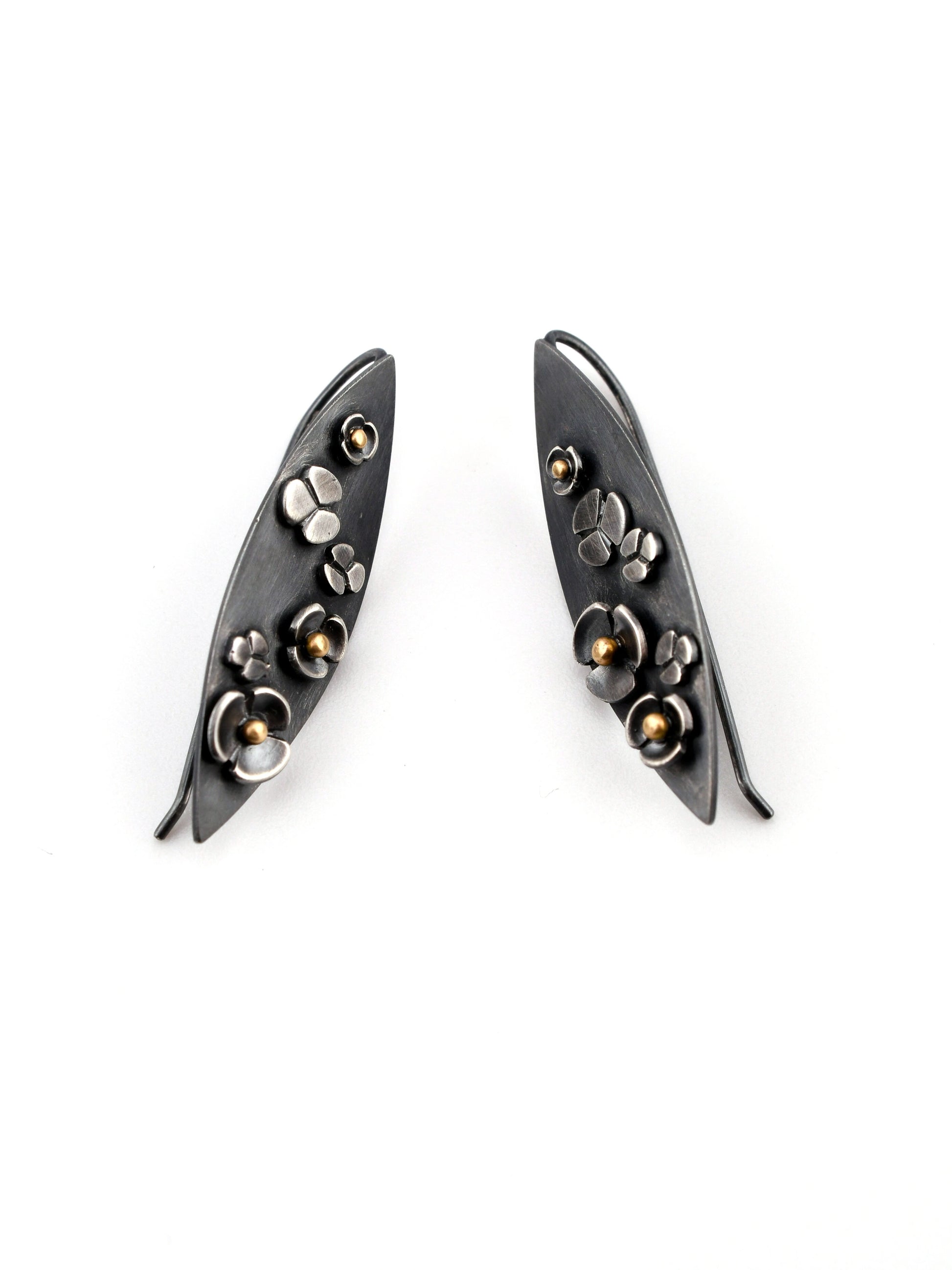 Pair of black earrings with floral designs on a white background
