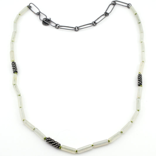 Necklace with pale green beads and black accents on a white background