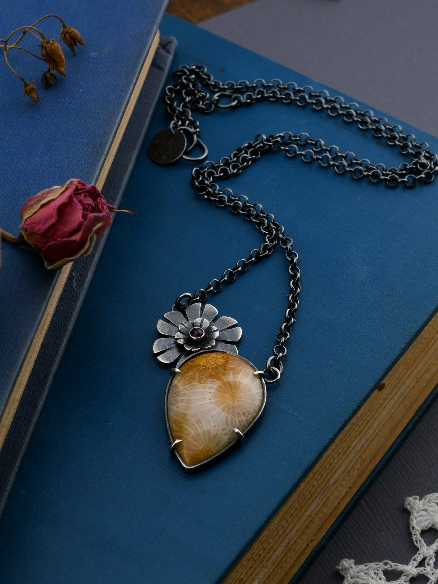 Necklace with a teardrop-shaped pendant on a blue surface