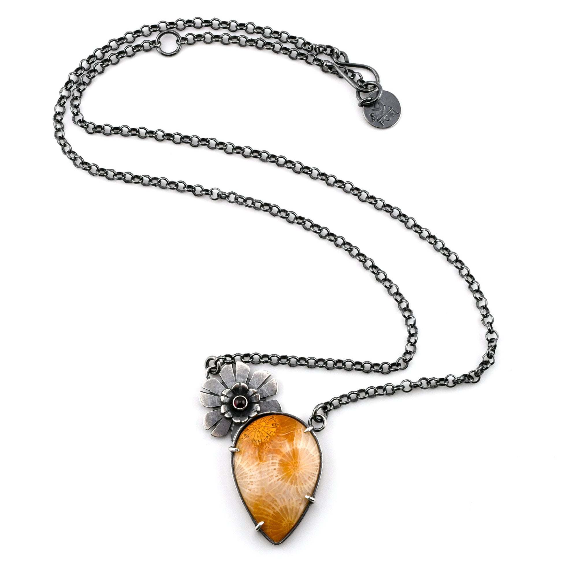 Necklace with a floral pendant and amber-colored stone on a white background