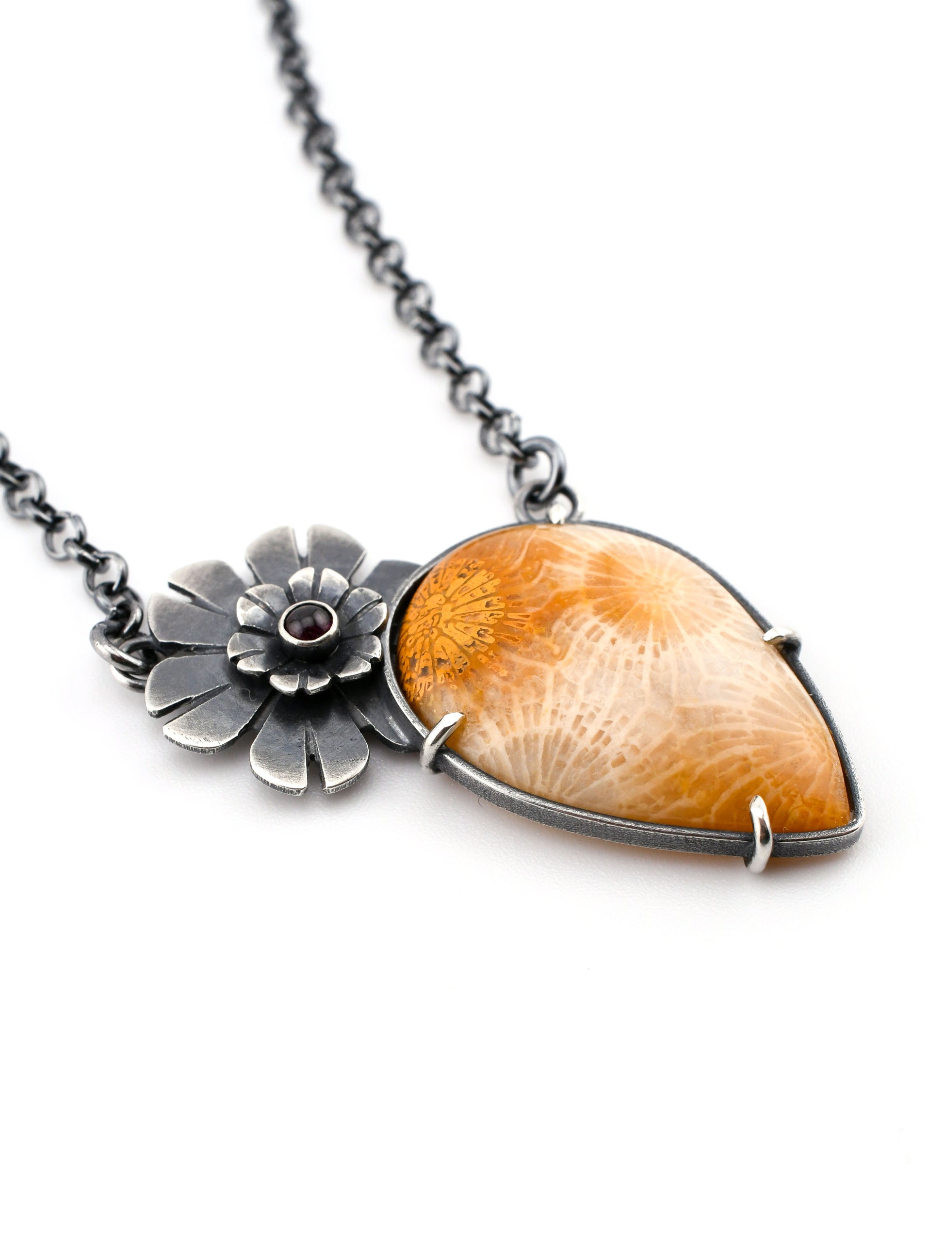 Necklace with a teardrop-shaped golden fossil coral pendant and floral design on a white background