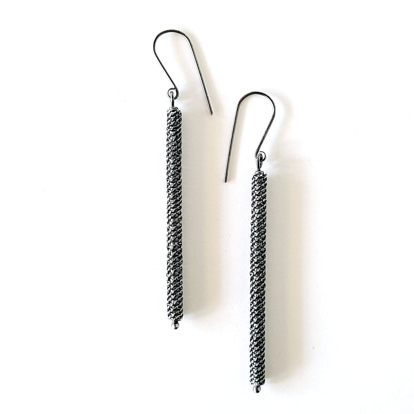 Pair of silver twisted wire pattern earrings on a white background
