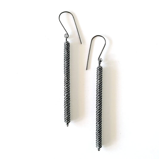 Pair of silver twisted wire pattern earrings on a white background