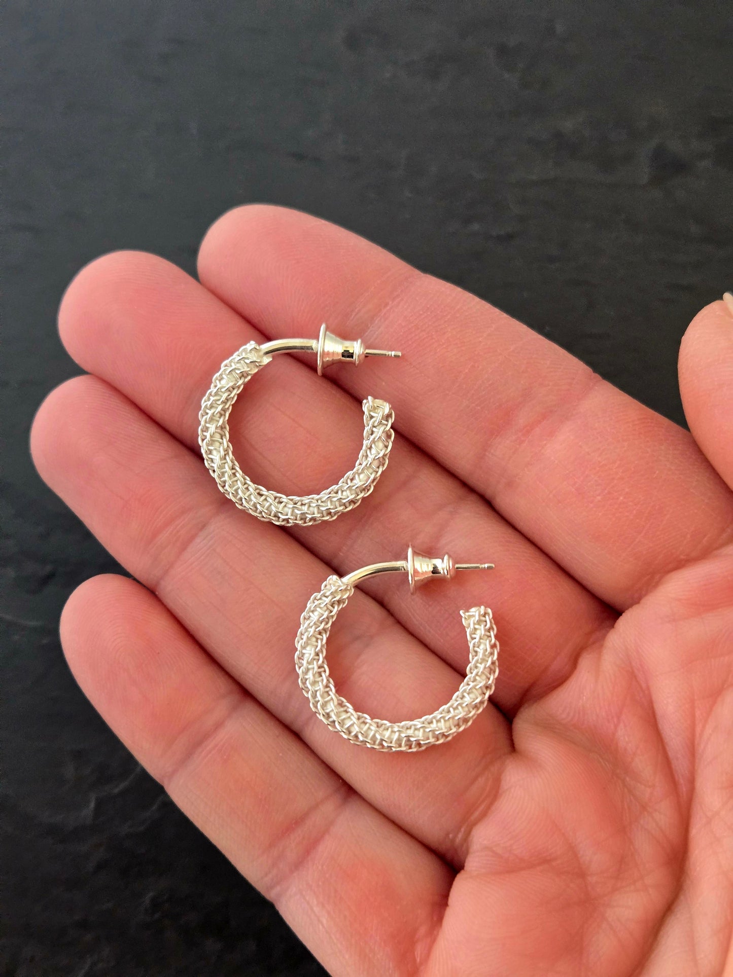 This image displays a pair of elegant Column Hoop studs. The earrings are crafted with a textured design that resembles a column pattern, adding a unique visual appeal.