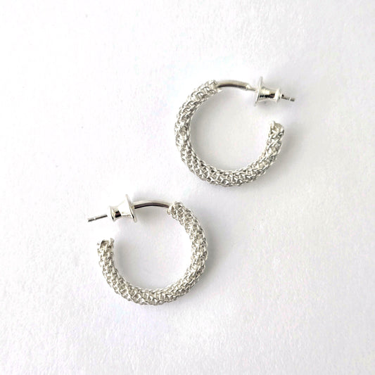 Pair of silver hoop earrings on a white background