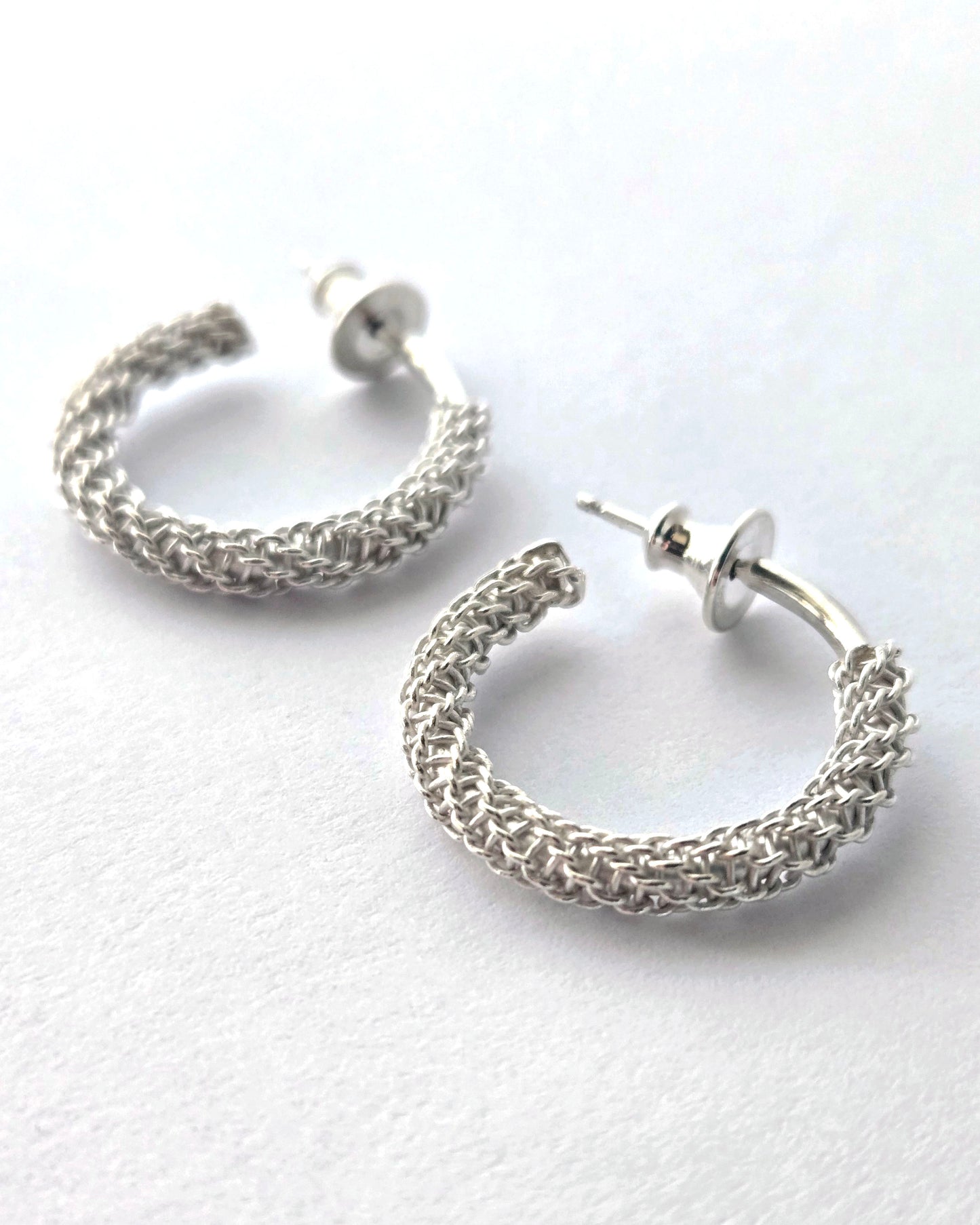 Pair of silver hoop earrings on a white background