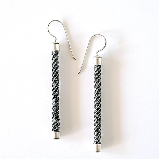 Pair of earrings with braided design on a white background