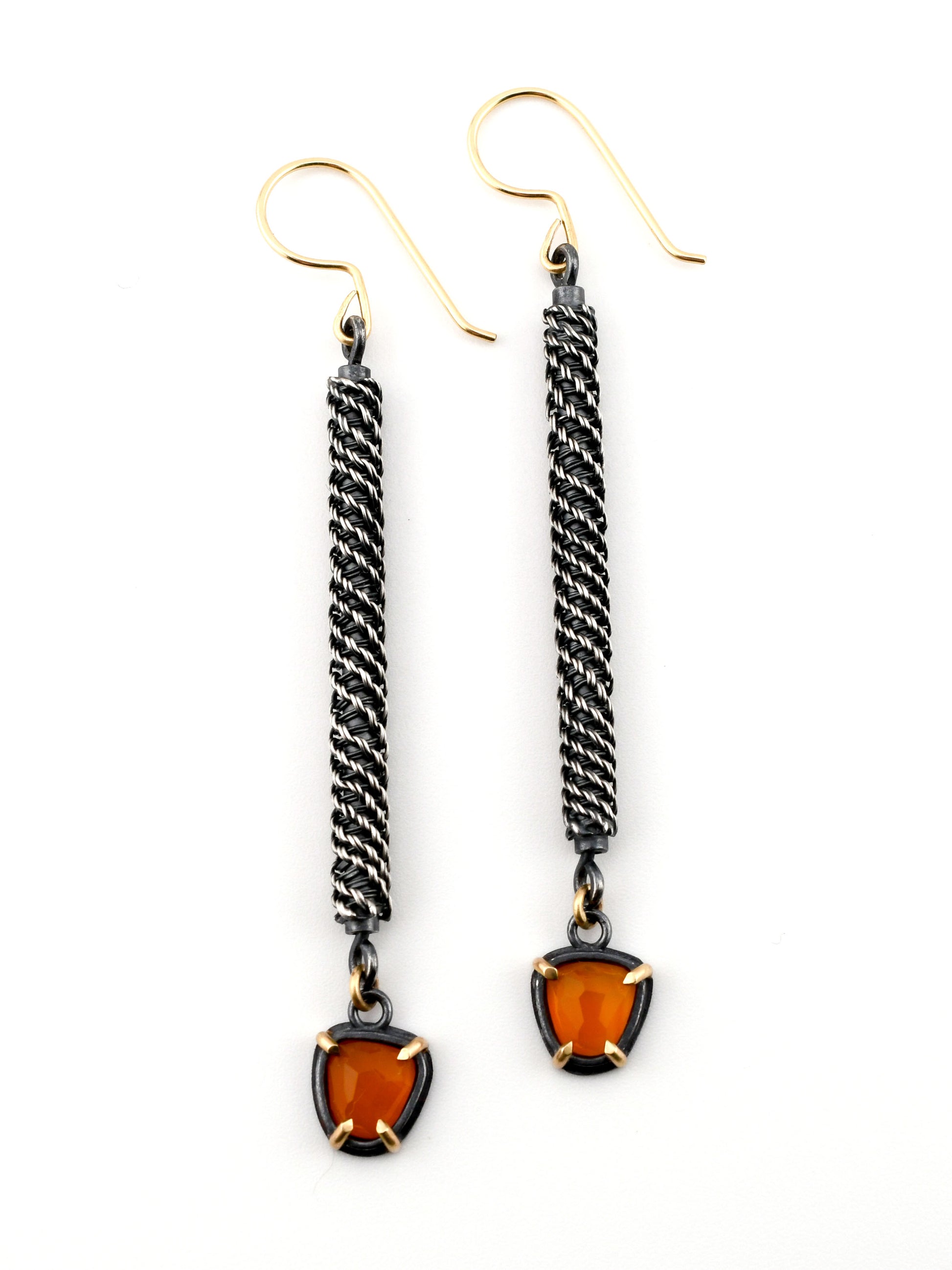 Pair of earrings with twisted wire design and amber-colored stones on a white background