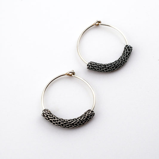Pair of hoop earrings with woven detailing on a white background