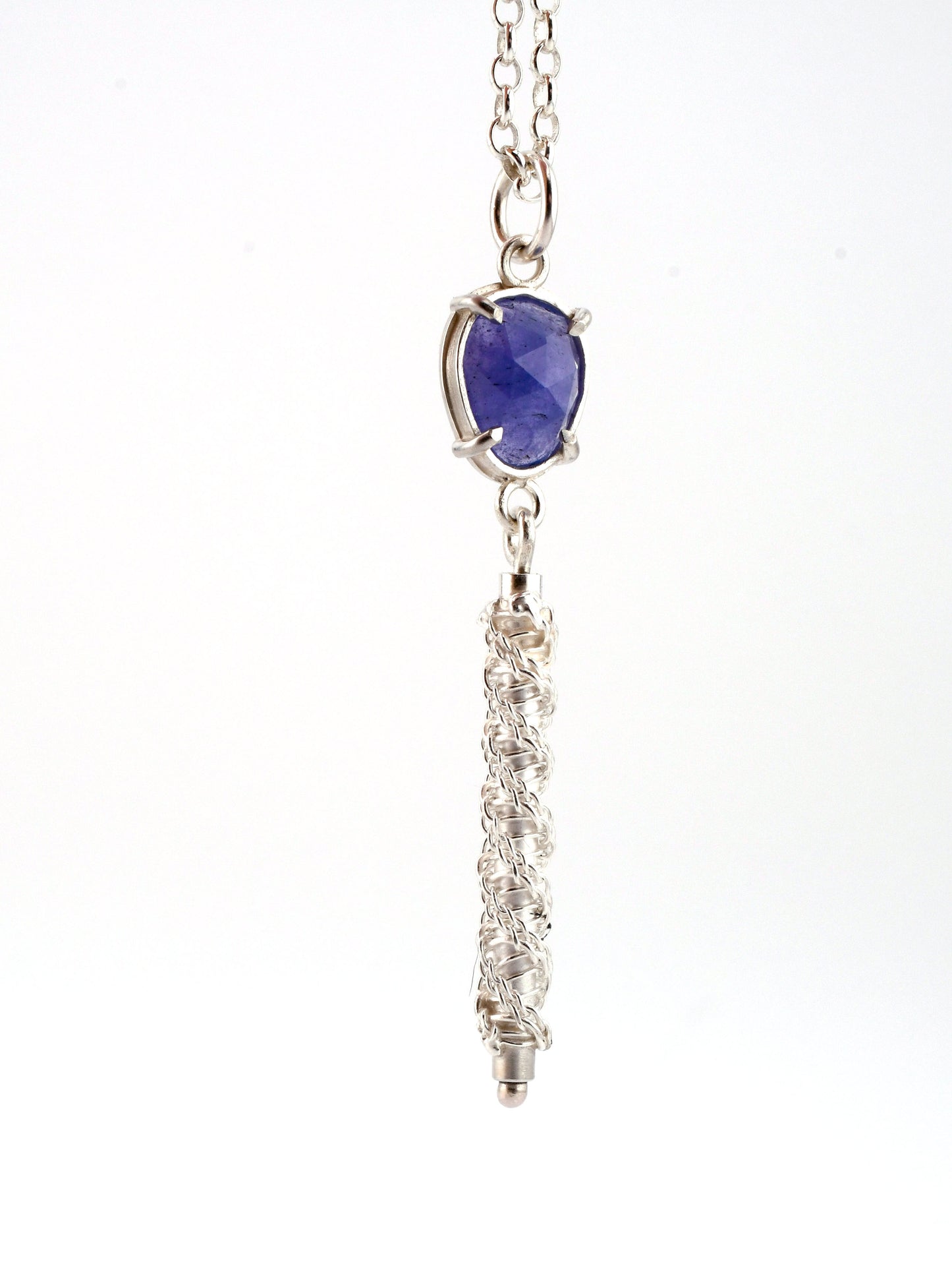 Silver necklace with a purple gemstone pendant on a white background