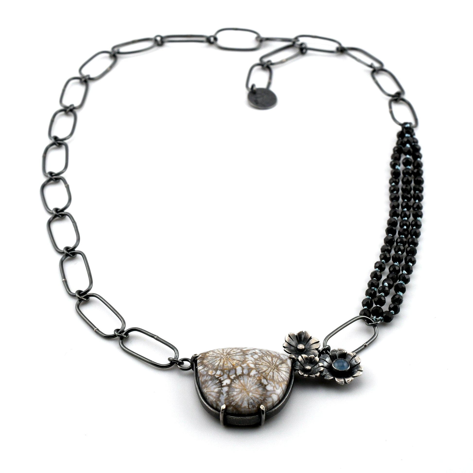 Necklace with floral design and gemstones on a white background