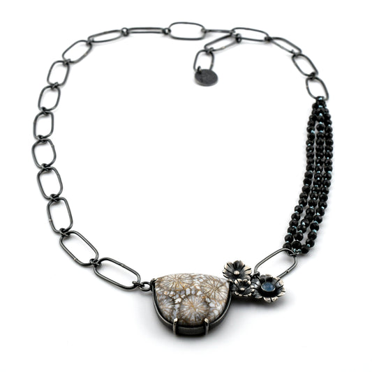 Necklace with floral design and gemstones on a white background