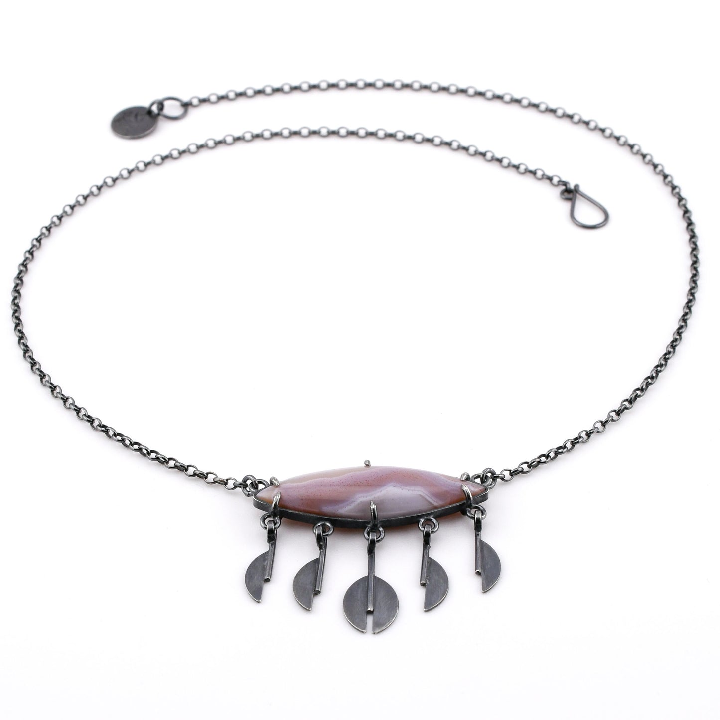 Necklace with a lavender stone and silver pendants on a white background