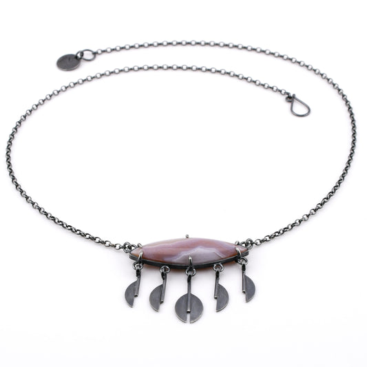 Necklace with a lavender stone and silver pendants on a white background