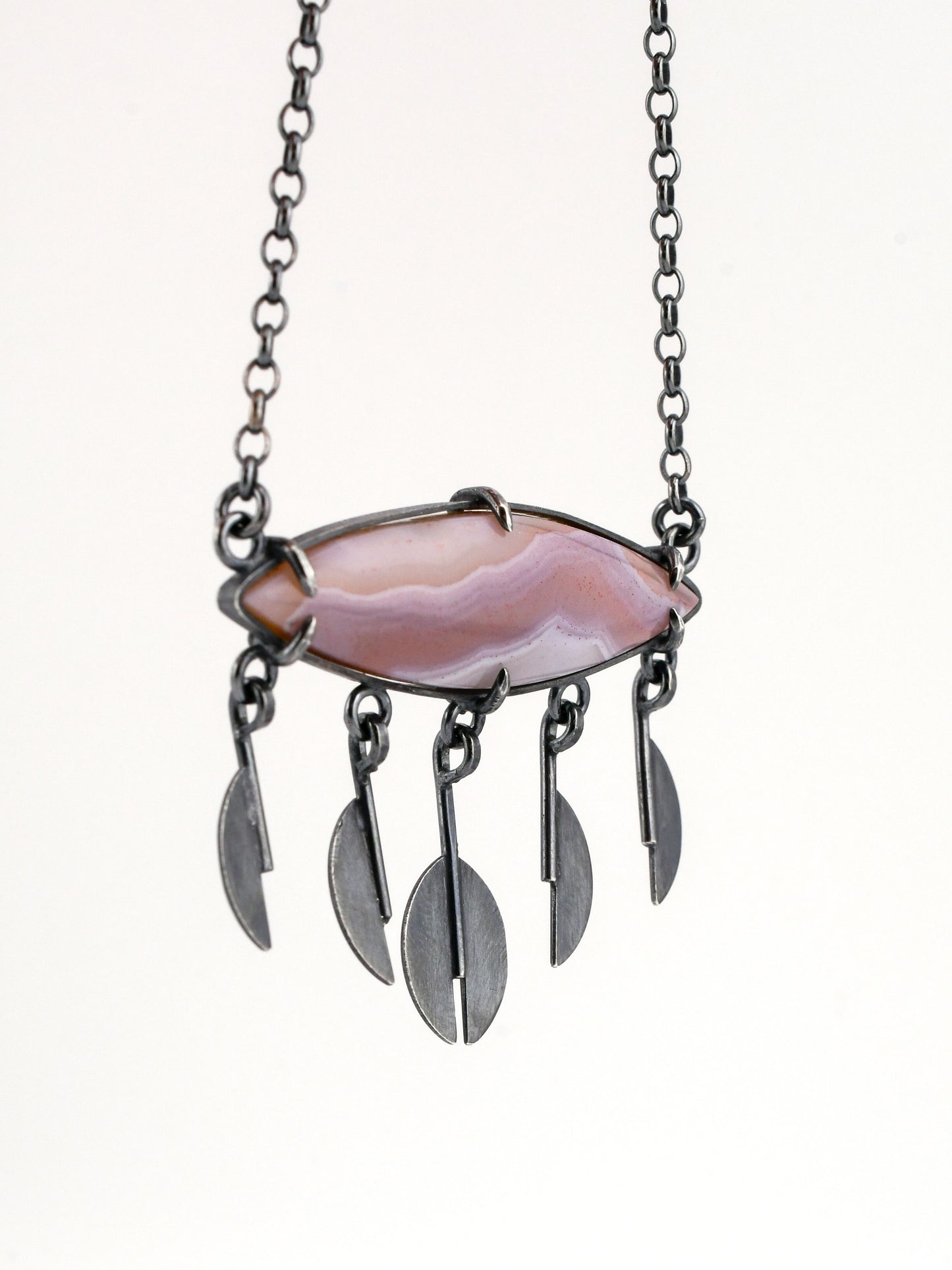 Necklace with a lavender and pink stone and silver rain pendants on a white background