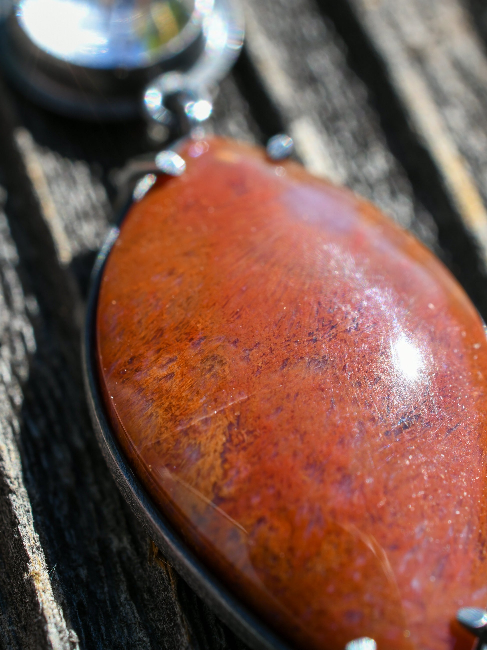 Close-up of a red stone on a wooden surface