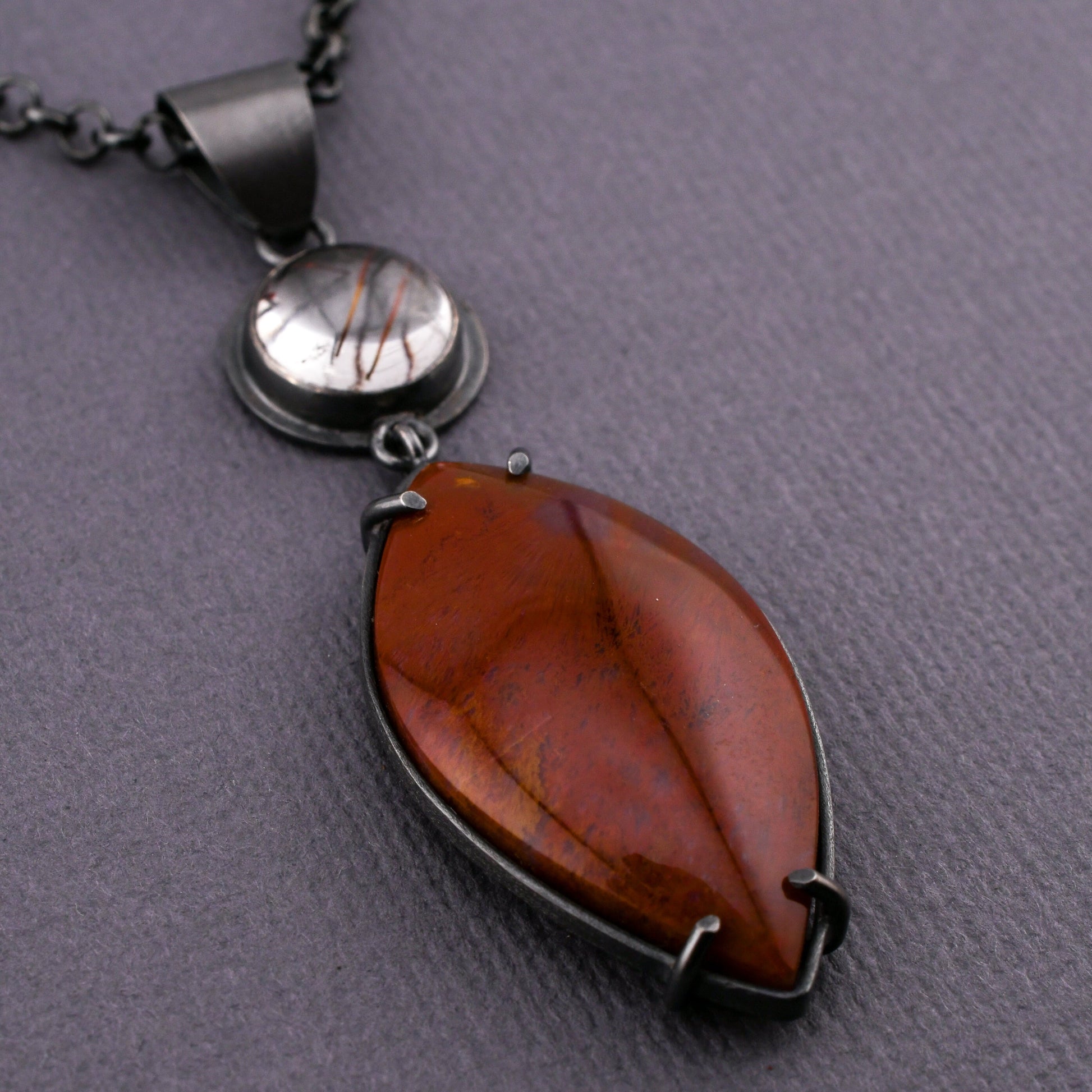 Necklace with a red stone pendant on a gray background