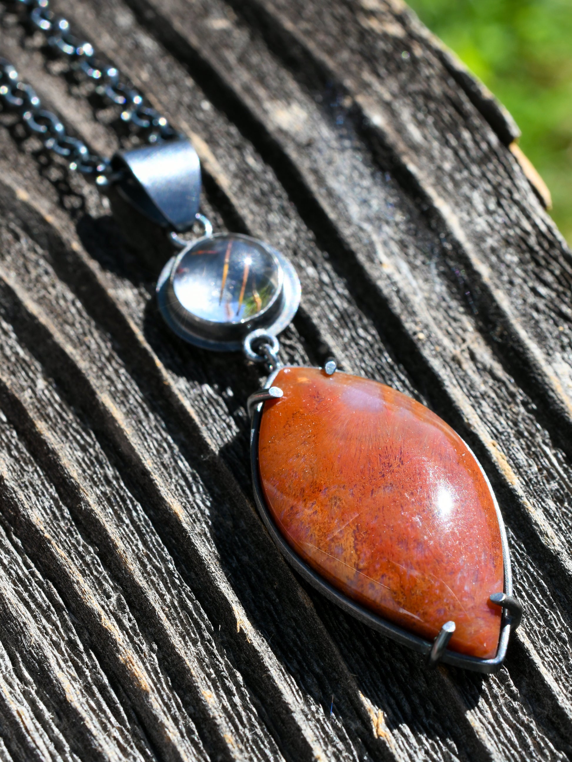 Necklace with a red stone pendant on a wooden surface