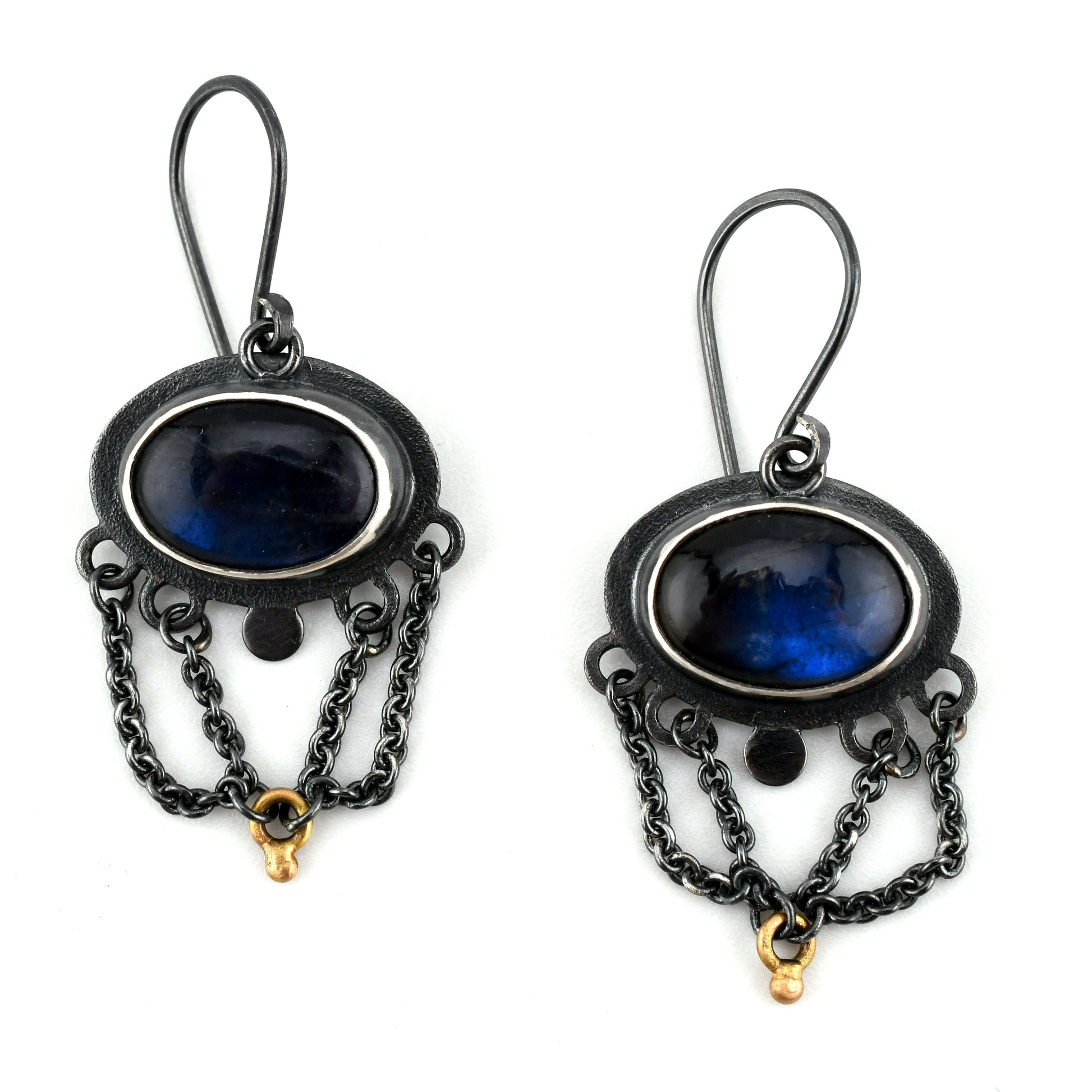 Pair of black-framed earrings with blue stones and chains on a white background