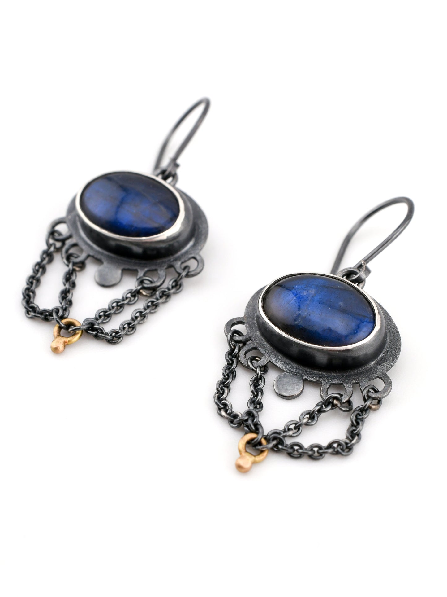 Pair of earrings with blue stones and chains on a white background