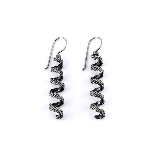 Pair of  woven silver spiral earrings on a white background