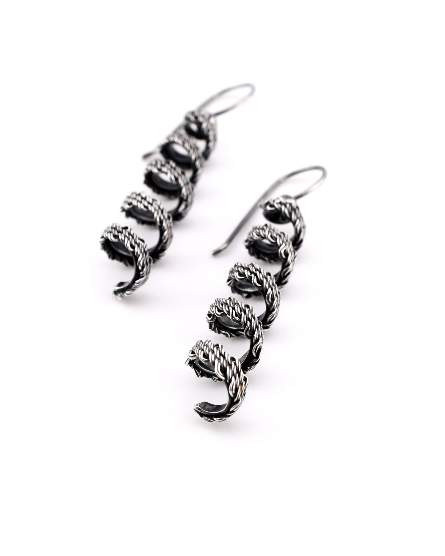 pair of woven silver coiled earrings on a white background
