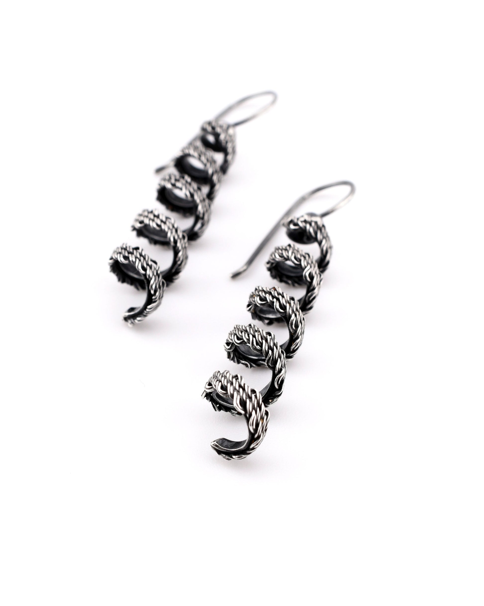 pair of woven silver coiled earrings on a white background