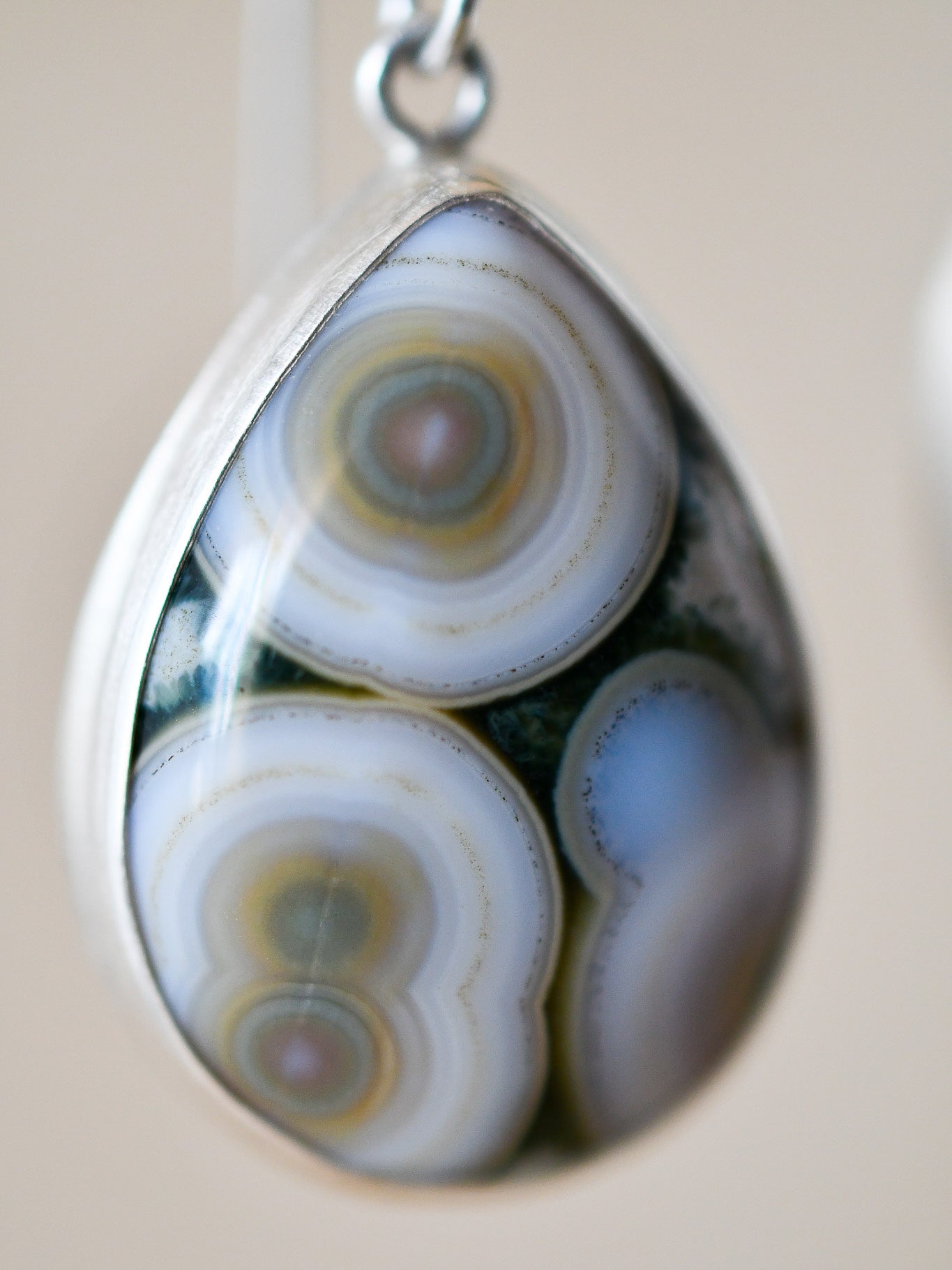 close-up of teardrop shaped ocean jasper with colorful circles in its surface