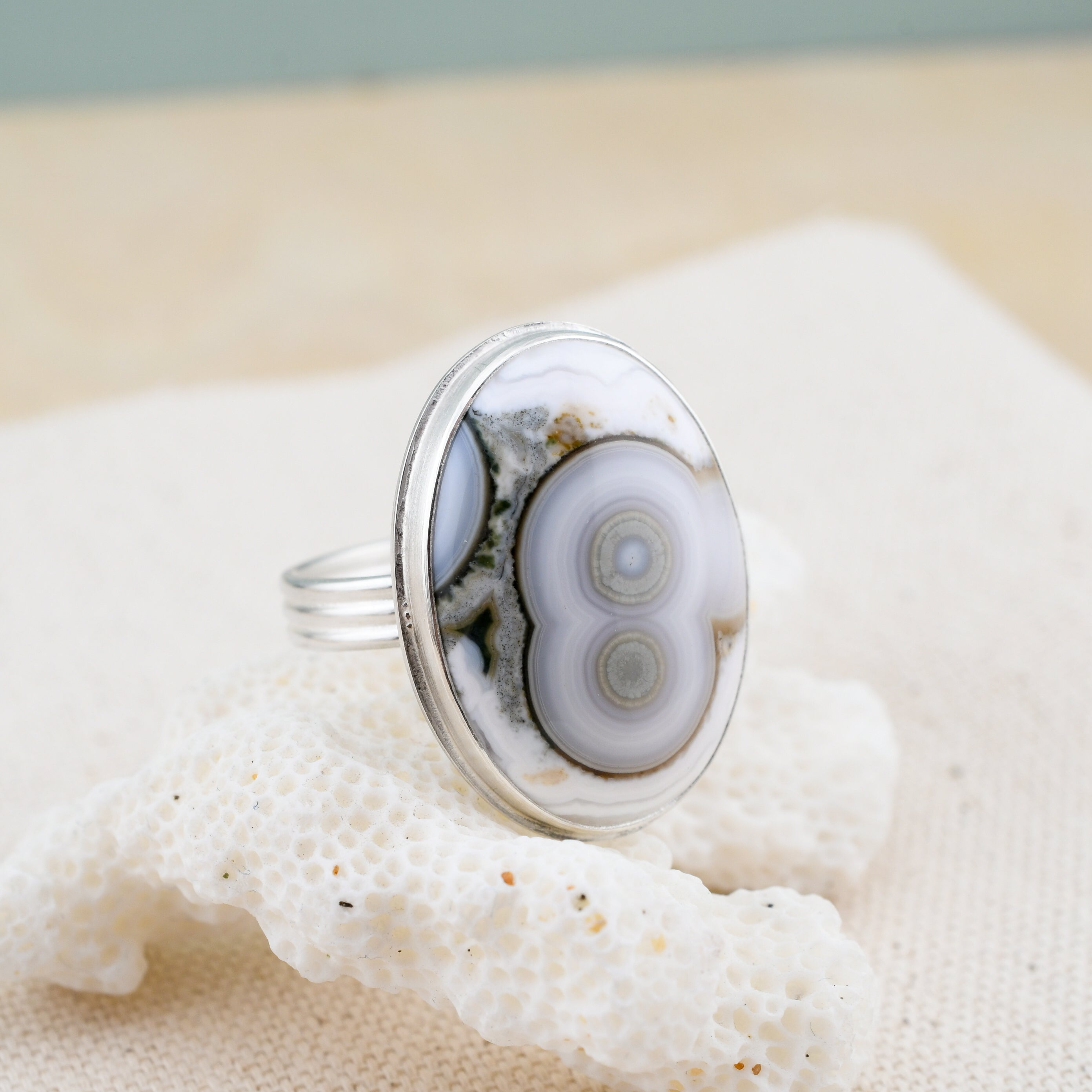Oval ocean jasper ring on white coral
