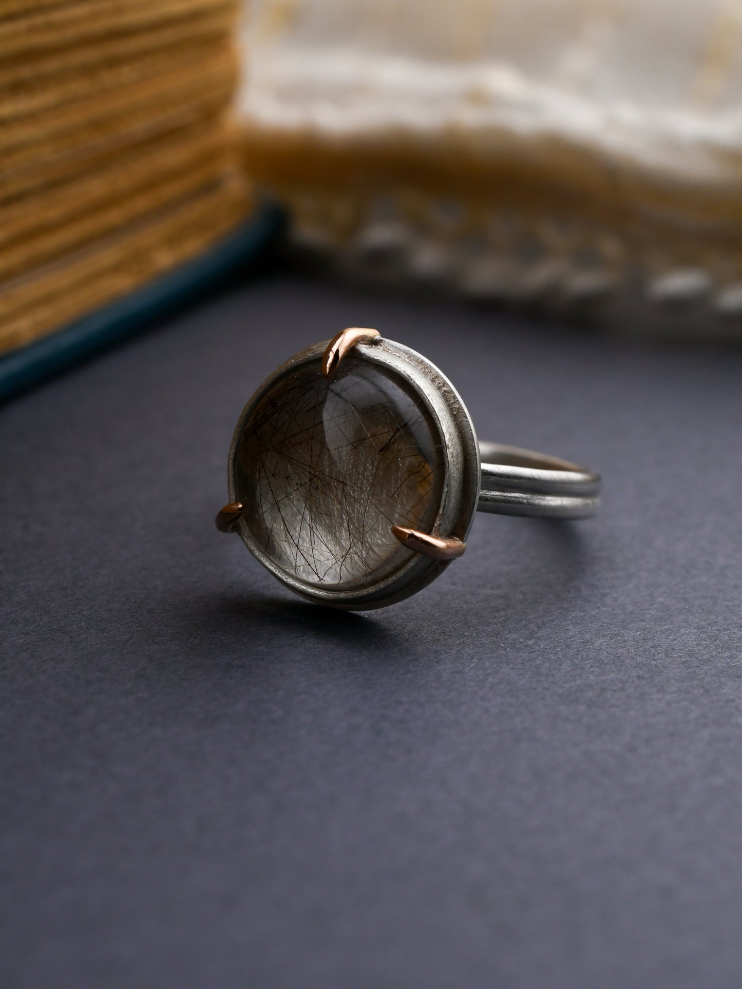 Silver ring with a stone on a dark surface